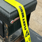 Black toolbox with a yellow 'Fleet Hero' strap on a concrete surface